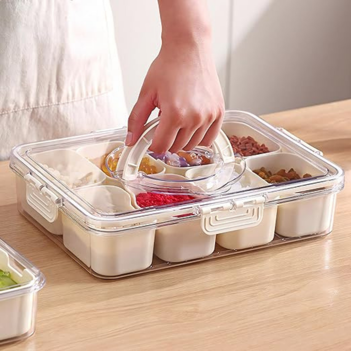 Clear food storage container with compartments on a wooden surface