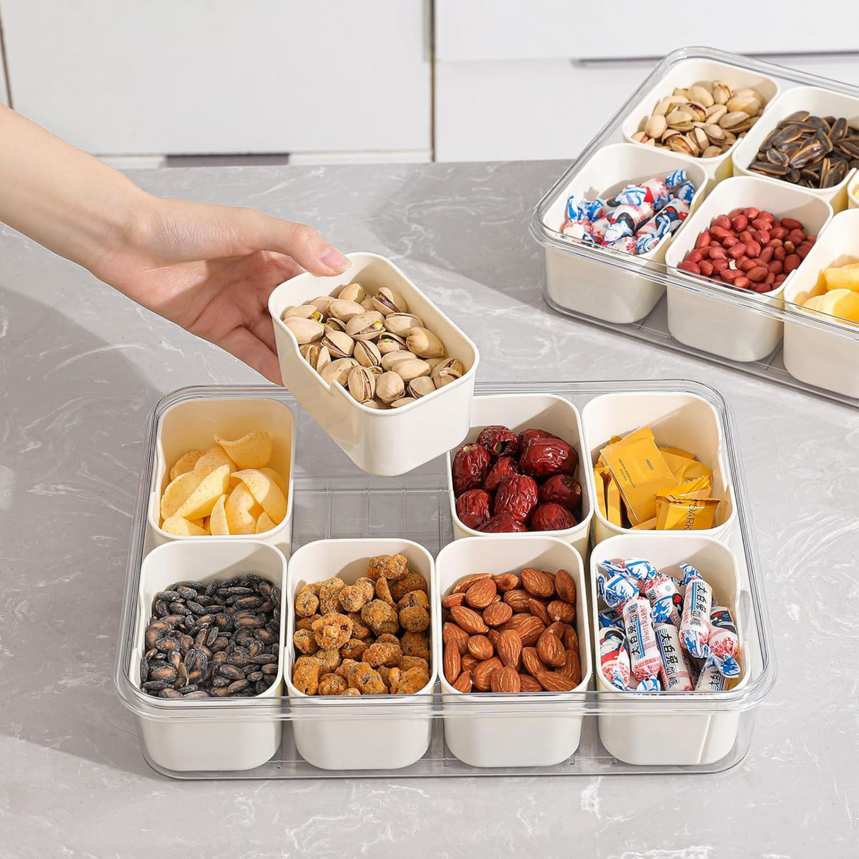 Hand reaching into a compartmentalized snack storage container with various snacks.