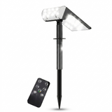 A modern black solar landscape light is shown with dual LED panels glowing brightly against a clean white background. Beside the stake-mounted light is a compact black remote control used to adjust the brightness and lighting modes.