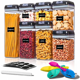 Assorted airtight containers filled with pasta, beans, snacks, and labels