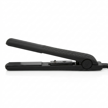 A profile view of the black Ginalli Milano Tourmaline Flat Iron resting on a white surface, showcasing its sleek design and open heating plates.