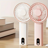 Two handheld mini fans with display in white and pink colors placed on a desk. Each handheld mini fan with display shows battery level on the screen.