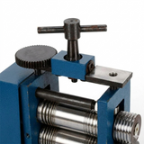 Close-up of jewelry rolling mill machine rollers and textured adjustment knobs