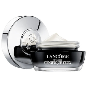 Lancome Advanced Genifique Eye Cream jar with silver lid placed beside it. The product shows a smooth cream texture inside the container.