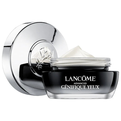 Lancome Advanced Genifique Eye Cream jar with silver lid placed beside it. The product shows a smooth cream texture inside the container.