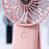 Close-up of handheld fan showing control button and LED indicators