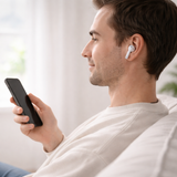 Man wearing wireless earbuds, using smartphone for hands-free listening
